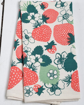 Floral and strawberry patterned towel on a wooden surface