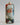 Decorative Christmas ornament with a painted face of Santa Claus on a plain background