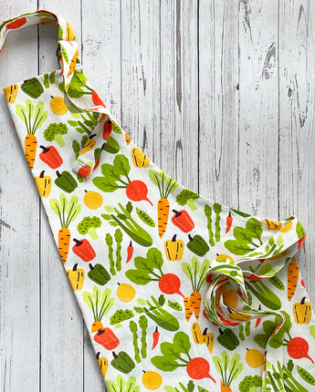 Colorful apron with vegetable pattern on a wooden surface