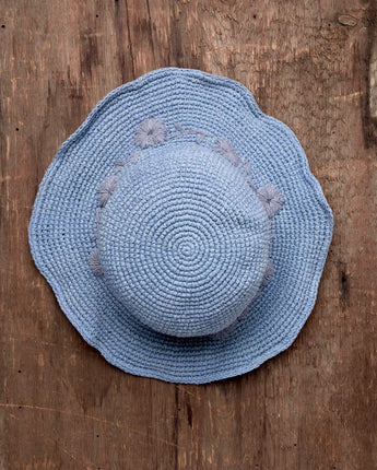 Blue straw hat on a wooden surface