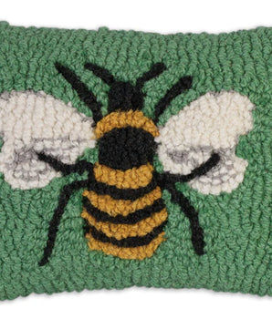 Textured green pillow with a bee design on a white background