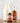 Three maple syrup products on a wooden surface with a light gray background