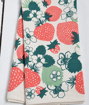 Floral and strawberry patterned towel on a wooden surface