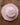 Pink woven hat with floral details on a wooden surface