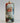 Decorative Christmas ornament with a painted face of Santa Claus on a plain background