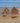 Two miniature gingerbread house salt and pepper shakers on a wooden surface with a blurred background.