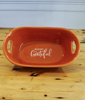 Orange ceramic dish with 'Forever Grateful' text on a wooden surface