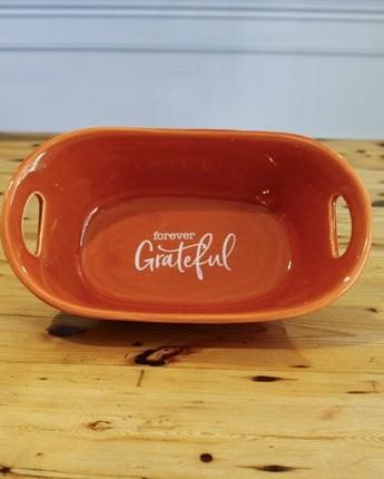 Orange ceramic dish with 'Forever Grateful' text on a wooden surface