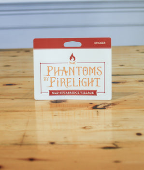 Packaging of 'Phantoms by Firelight' stickers from Old Sturbridge Village on a wooden surface.