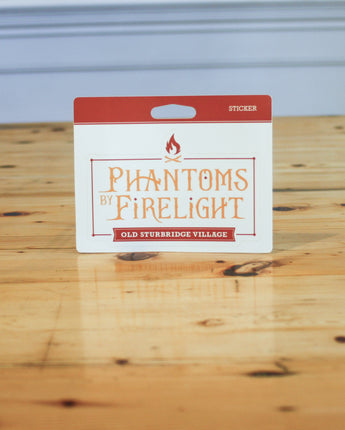 Packaging of 'Phantoms by Firelight' stickers from Old Sturbridge Village on a wooden surface.