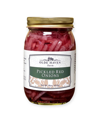 Jar of pickled red onions with a gold lid on a white background