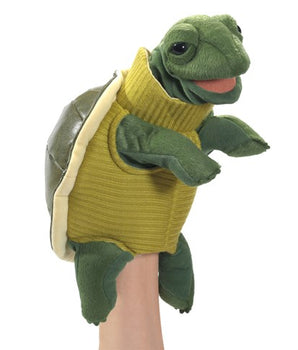 Green turtle puppet with a yellow sweater on a white background