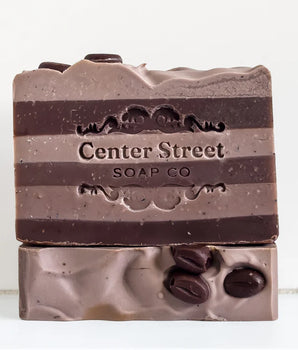 Two layered soap bars with chocolate chips on a white background, featuring 'Center Street Soap Co' branding.